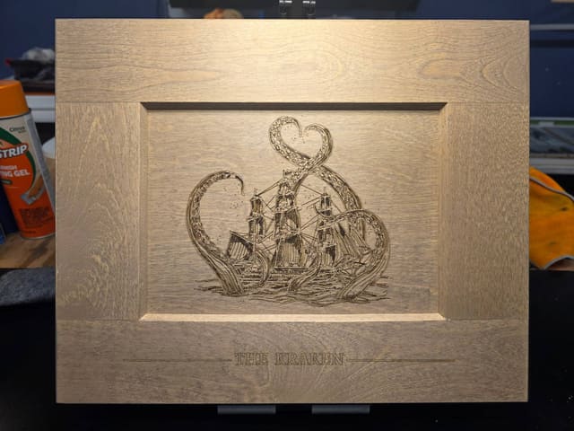 Wood cabinet door laser-etched with a kraken and tall ship